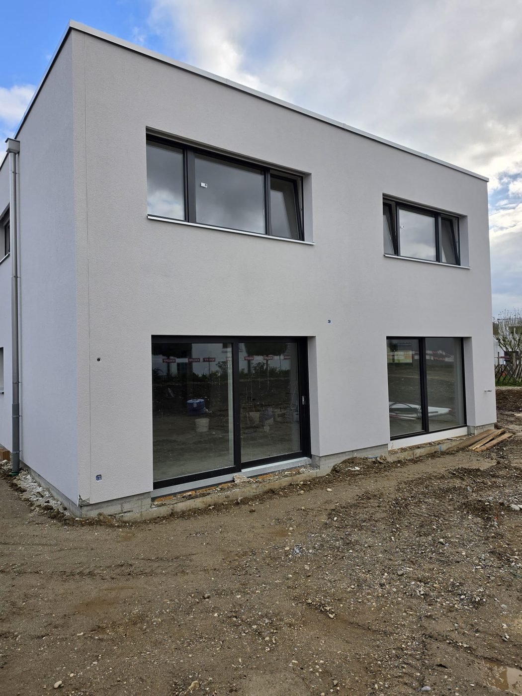 Fertig verputzte Fassade, Eckansicht mit grosser Fensterfront